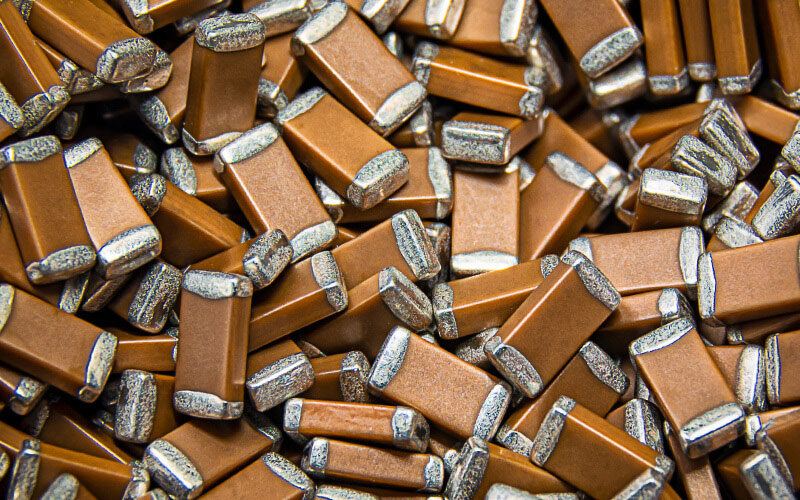 A large pile of brown ceramic chip capacitors with silver-colored ends
